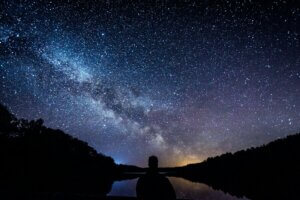 silhouette of person standing under starry sky